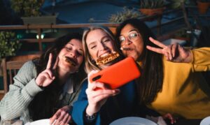 Young,Friends,Eating,Pizza,In,Outdoor,Restaurant.,Group,Of,Women