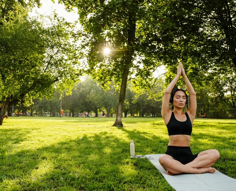 Young,Brunette,Asian,Woman,Practicing,Yoga,During,Workout,In,Park