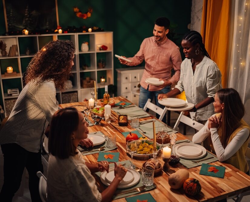 Happy,Multiethnic,Friends,Setting,The,Table,For,Thanksgiving,Or,Friendsgiving
